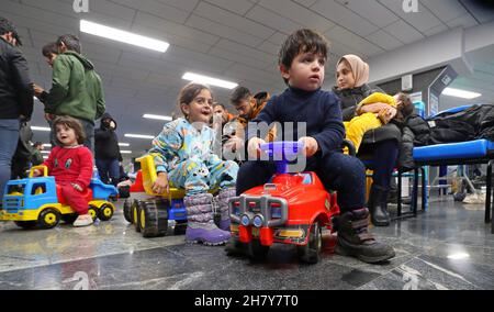 Minsk, Bielorussia. 25 Nov 2021. I migranti iracheni bloccati attendono di tornare in Iraq all'aeroporto internazionale di Minsk, in Bielorussia, il 25 novembre 2021. Il Ministero degli Esteri iracheno ha detto giovedì che ha evacuato 617 migranti bloccati in Bielorussia, la maggior parte dei quali sono donne, bambini e anziani. Migliaia di migranti si sono riuniti sul lato bielorusso del confine con la Polonia, nel tentativo di entrare in Polonia e poi in Germania per chiedere asilo nei paesi europei. Credit: Henadz Zhinkov/Xinhua/Alamy Live News Foto Stock