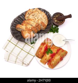 Porzione di involtini di cavolo ripieni di manzo macinato e riso con panna acida su un piatto Foto Stock