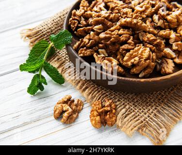 Noci senza guscio su fondo bianco di legno Foto Stock