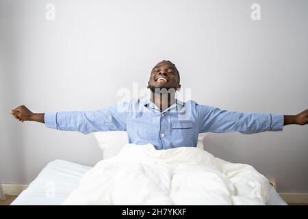 Giovani Sorridenti Africano di svegliarvi in camera da letto Foto Stock
