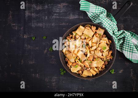 Calamarata di pasta con carne di pollo, funghi e salsa di soia. Cucina italiana. Vista dall'alto, dall'alto Foto Stock