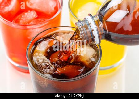 Versare la cola drink bibite alla limonata in un bicchiere Foto Stock