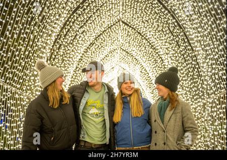 25 novembre 2021 Natale al Botanics 2021 Royal Botanics Gardens Edimburgo notte di apertura il Natale annuale al Botanics light show al Royal Botanics Gardens di Edimburgo. Image Sows l-r Olivia Bropht, Owen Rippen, Elise Chabason e Sophie Lynch godendo l'installazione della Cattedrale della luce. Credit: phil wilkinson/Alamy Live News Foto Stock