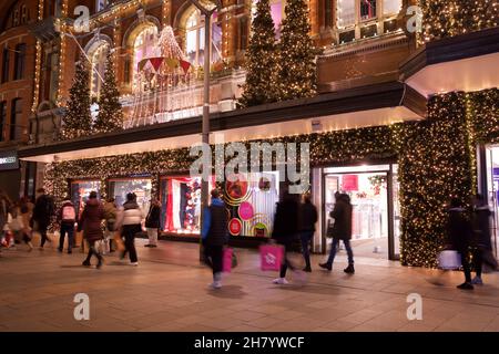 Dublino, Irlanda - 24 novembre 2021: Gli acquirenti passano le luci e le decorazioni natalizie presso il grande magazzino Arnotts di Henry Street, The Foto Stock