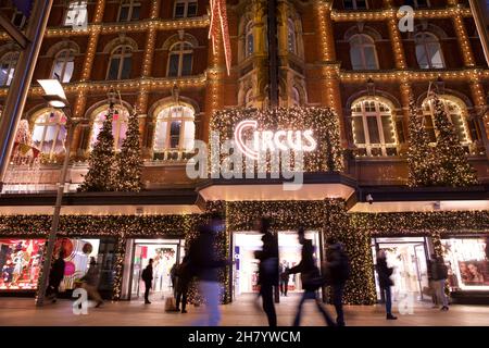 Dublino, Irlanda - 24 novembre 2021: Gli amanti dello shopping passano le luci e le decorazioni natalizie a tema circense presso il grande magazzino Arnotts di Henr Foto Stock