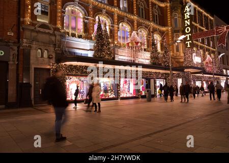 Dublino, Irlanda - 24 novembre 2021: Gli acquirenti passano le luci e le decorazioni natalizie presso il grande magazzino Arnotts di Henry Street, The Foto Stock