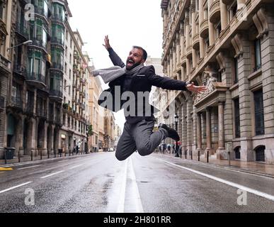 Un giovane salta in Via Laietana, Barcellona, in una giornata invernale e piovosa Foto Stock