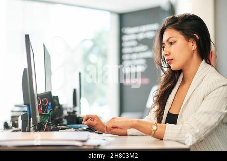 giovane donna d'affari latina che lavora nel suo ufficio Foto Stock