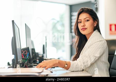 giovane donna d'affari latina che lavora nel suo ufficio Foto Stock