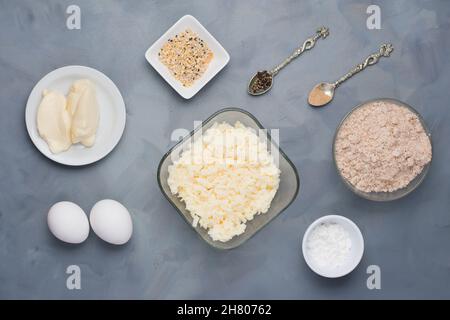 Vista dall'alto di vari prodotti per bagel a basso contenuto di carboidrati con formaggio caserma e mozzarella vicino alla farina sul tavolo con spezie Foto Stock