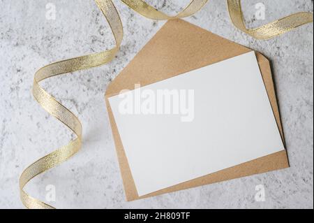 Una carta vuota con busta e foglia viene posizionata su sfondo bianco Foto Stock