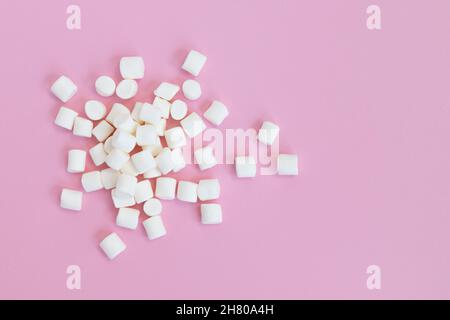 mucchio di marshmallows su sfondo bianco, vista piatta o dall'alto, sfondo o texture di mini marshmallows bianchi, concetto invernale, cibo dolce Foto Stock