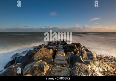 mare roccioso difesa frangiflutti sul litorale dell'isola di wight circondato da mari e onde tempestose, vecchio molo di pietra sulla costa isola di wight. Foto Stock