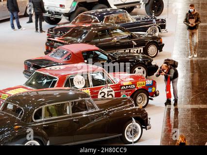 Essen, Germania. 26 novembre 2021. I visitatori del settore guardano le auto classiche sintonizzate alla fiera di tuning "Essen Motor Show". Circa 400 espositori vogliono presentare veicoli e accessori in otto sale dal 27.11. Al 05.12.2021. Credit: Roland Weihrauch/dpa/Alamy Live News Foto Stock