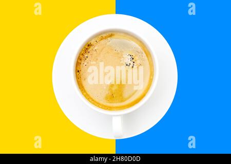 Tazza espresso con piattino bianco su sfondo giallo e blu a contrasto Foto Stock