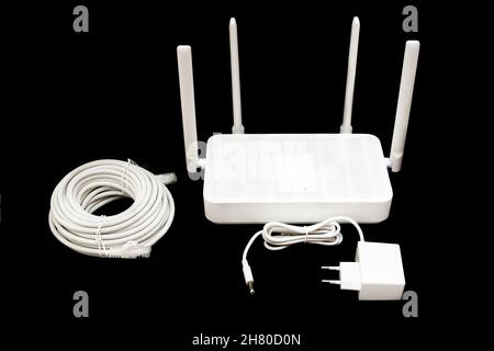 Router Wi-Fi 6 dual band con adattatore di alimentazione e un rotolo di cavo ethernet isolato in nero. Foto Stock