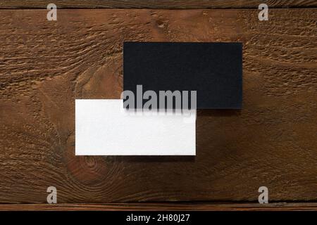 Moderno modello mockup di biglietti da visita su sfondo di legno. Le carte in bianco e nero si appiattire con la copia spcae. Disegno mock-up per marcare a caldo, pubblicità a Foto Stock