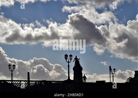 Silhouette del 1916 Monumento, Sarsfield Bridge, contro un cielo blu nuvoloso (Limerick, Éire) Foto Stock