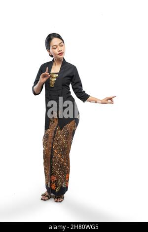 Giovane donna che indossa il tradizionale abito giavanese Kebaya pone un gesto di danza mano Foto Stock