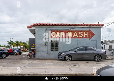 Hollywood, USA - 10 luglio 2021: Cartello per il lavaggio auto nel centro della città a North Miami, Florida con architettura retrò vintage e la gente su strada Foto Stock