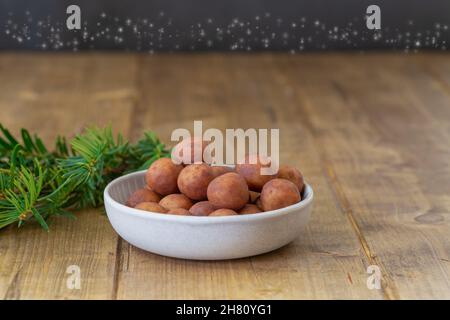 Primo piano di una porzione di patate marzapane in una piccola ciotola su un tavolo di legno con fuoco in primo piano Foto Stock