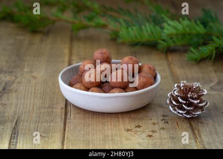 Primo piano di una porzione di patate marzapane in una piccola ciotola su un tavolo di legno con fuoco in primo piano Foto Stock