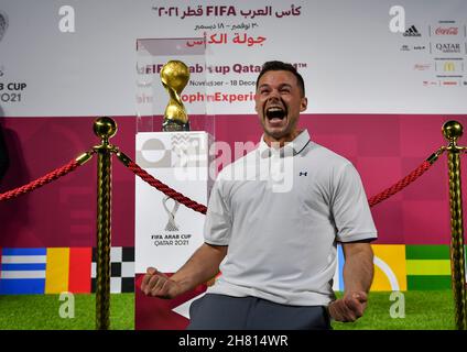 Doha. 25 Nov 2021. Un fan si pone per scattare foto con il trofeo durante l'esperienza del trofeo FIFA Arab Cup al Katara Cultural Village di Doha, Qatar, il 25 novembre 2021. La FIFA Arab Cup si svolgerà in Qatar dal 30 novembre al 18 dicembre 2021. Credit: Nikku/Xinhua/Alamy Live News Foto Stock