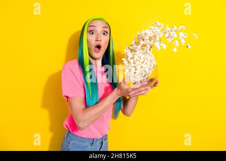 Foto di paura paura giovane vibrante donna indossare rosa t-shirt lancio popcorn guardando horror isolato colore giallo sfondo Foto Stock