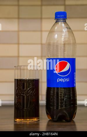 POZNAN, POLONIA - Feb 04, 2018: Un colpo verticale di un Pepsi Cola in una bottiglia di plastica in un bicchiere di Coca-Cola sul tavolo Foto Stock