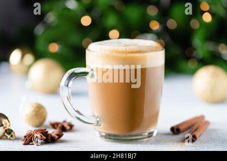 Tazza di cappuccino di Natale caffè con cannella, albero di Natale con luci sullo sfondo Foto Stock