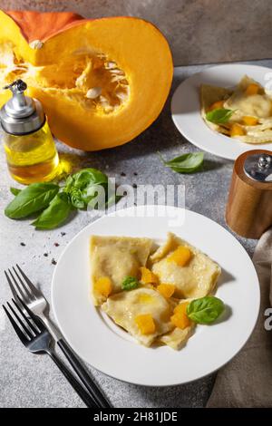 Ravioli fatti in casa di ricotta di zucca italiana su un tavolo in pietra grigia. Foto Stock