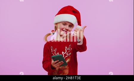 Felice ragazza in Natale maglione cervi guardando smartphone display sinceramente gioire vincere fortuna successo Foto Stock