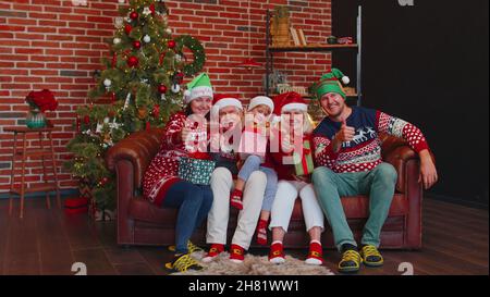 Famiglia multigenerazionale scattando foto selfie sul telefono mobile del timer alla casa decorata di Natale Foto Stock