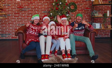 Risate la famiglia che sventola le mani ciao, ciao, saluto mentre si prende selfie su smartphone a casa di Natale Foto Stock