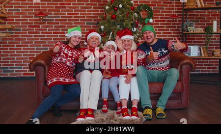 Famiglia multigenerazionale scattando foto selfie sul telefono mobile del timer alla casa decorata di Natale Foto Stock