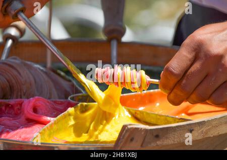 Venditore preparare tradizionali turchi candy stick su strada Foto Stock