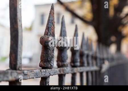 Vecchia recinzione in metallo forgiato arrugginito, foto ravvicinata con messa a fuoco selettiva. Architettura classica della città vecchia di San Pietroburgo, Russia Foto Stock