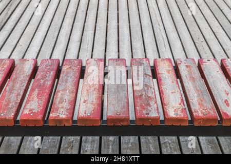 Panca esterna con intemperie rosse con pavimento a Promenade vuoto. Foto astratta di sfondo, prospettiva tavole di legno Foto Stock