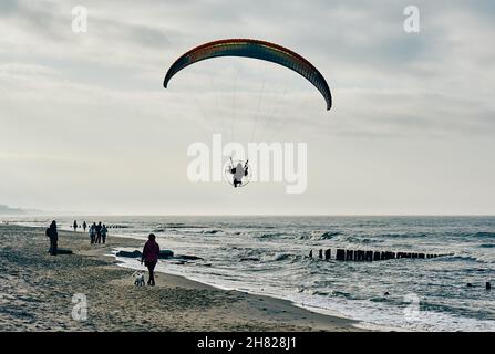 SARBINOWO, POLONIA - 15 ottobre 2017: Una spiaggia sabbiosa a Sarbinowo, Polonia con persone che camminano vicino all'acqua in una giornata ventosa Foto Stock