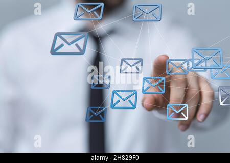 Uomo che tocca un ologramma di icone e-mail Foto Stock