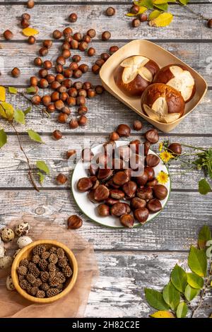 Ancora vita con muffin, castagne mature, nocciole, uova di quaglia e foglie d'autunno Foto Stock
