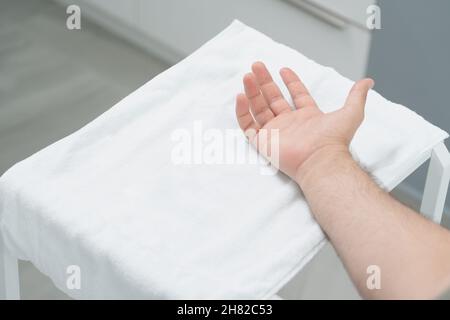 il medico fa un colpo di tossina botulinica nelle mani di un palmo maschio contro sudorazione eccessiva, trattamento di iperidrosi Foto Stock