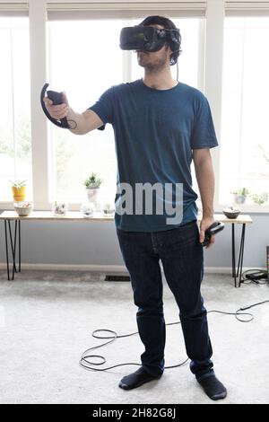 Un giovane che gioca in realtà virtuale. Foto Stock