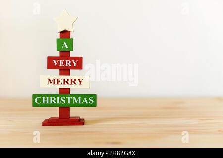 Albero decorativo di Natale in legno su tavola con spazio di copia per il testo. Un buon Natale Foto Stock