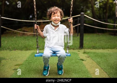 Bambini in altalena nel parco giochi Foto Stock