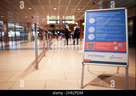 Amburgo, Germania. 25 Nov 2021. Un cartello con le informazioni e le regole di condotta dovute alla pandemia di Corona si trova al controllo d'ingresso della polizia federale presso l'aeroporto di Amburgo. A causa delle regole di viaggio più severe di Corona, i viaggiatori devono anche aspettarsi tempi di attesa più lunghi all'aeroporto di Amburgo quando entrano nel paese. Credit: Christian Charisius/dpa/Alamy Live News Foto Stock