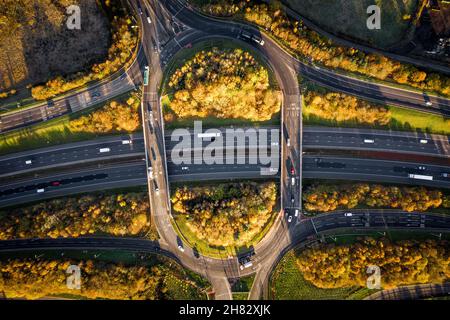 Vista aerea direttamente sopra una rotatoria sul cavalcavia all'incrocio dell'autostrada M1 in un ambiente di campagna Foto Stock