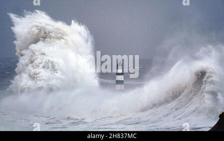 Enormi onde si scontrano contro il faro di Seaham Harbour, County Durham, alla fine della coda di Storm Arwen che ha visto raffiche di quasi 100 miglia all'ora in aree devastanti del Regno Unito. Data foto: Sabato 27 novembre 2021. Foto Stock