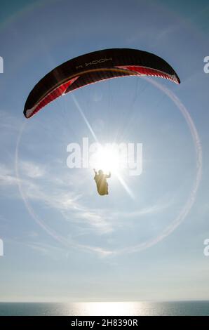 Parapendio sopra il mare a Barton on on Sea, Hampshire, Inghilterra, Regno Unito Foto Stock