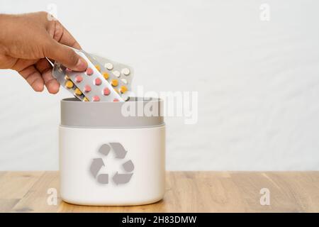 Pieno di pillole scadute e medicinali nel cestino con il simbolo di riciclaggio. Pillole di scarto raccolte per essere riciclate. Concetto di gestione dei rifiuti. Foto Stock